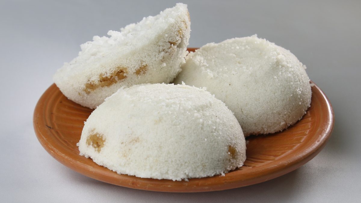 A serving plate contains three pieces of pitha assamese rice cake 