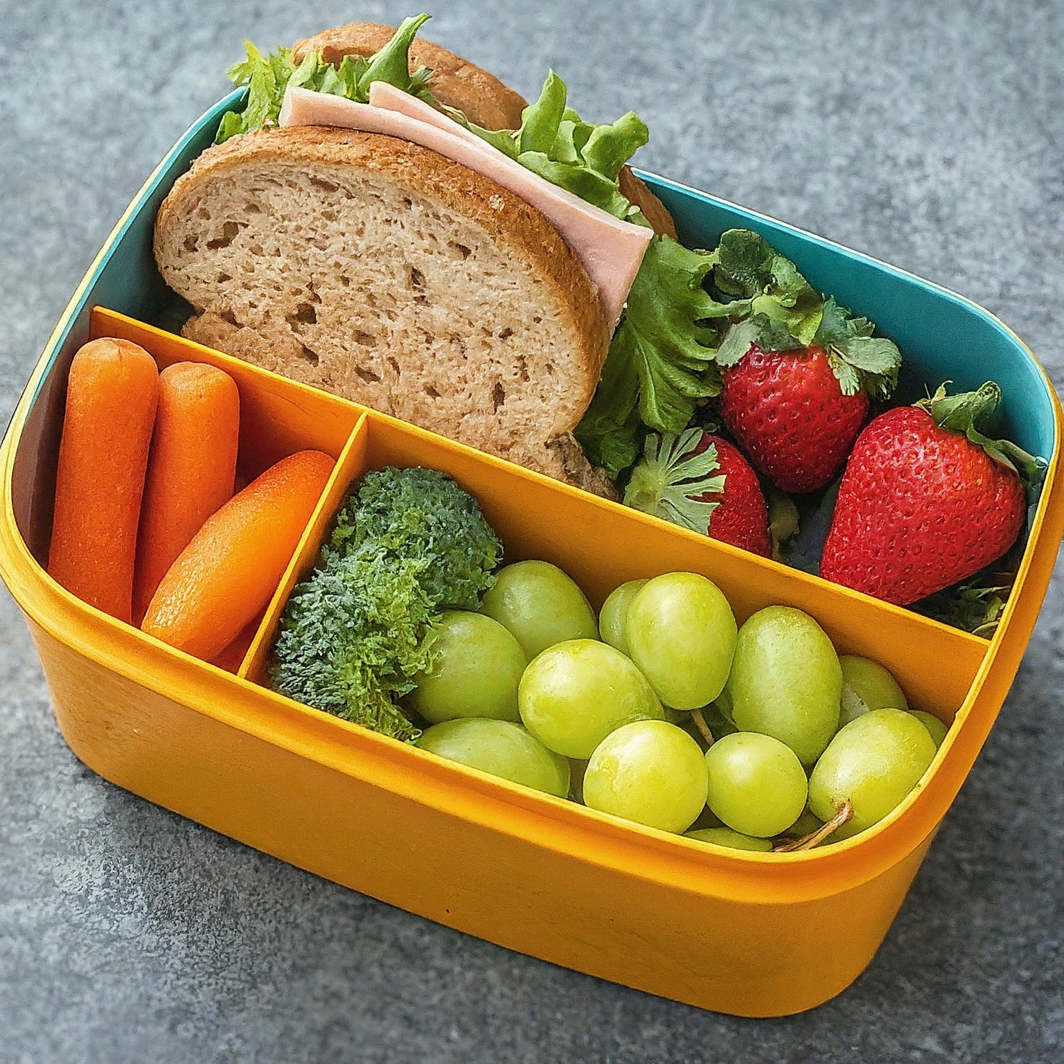 lunch box filled with fresh fruits and bread