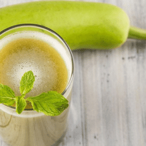 A glass of Bottle Gourd Smoothie garnished with mint