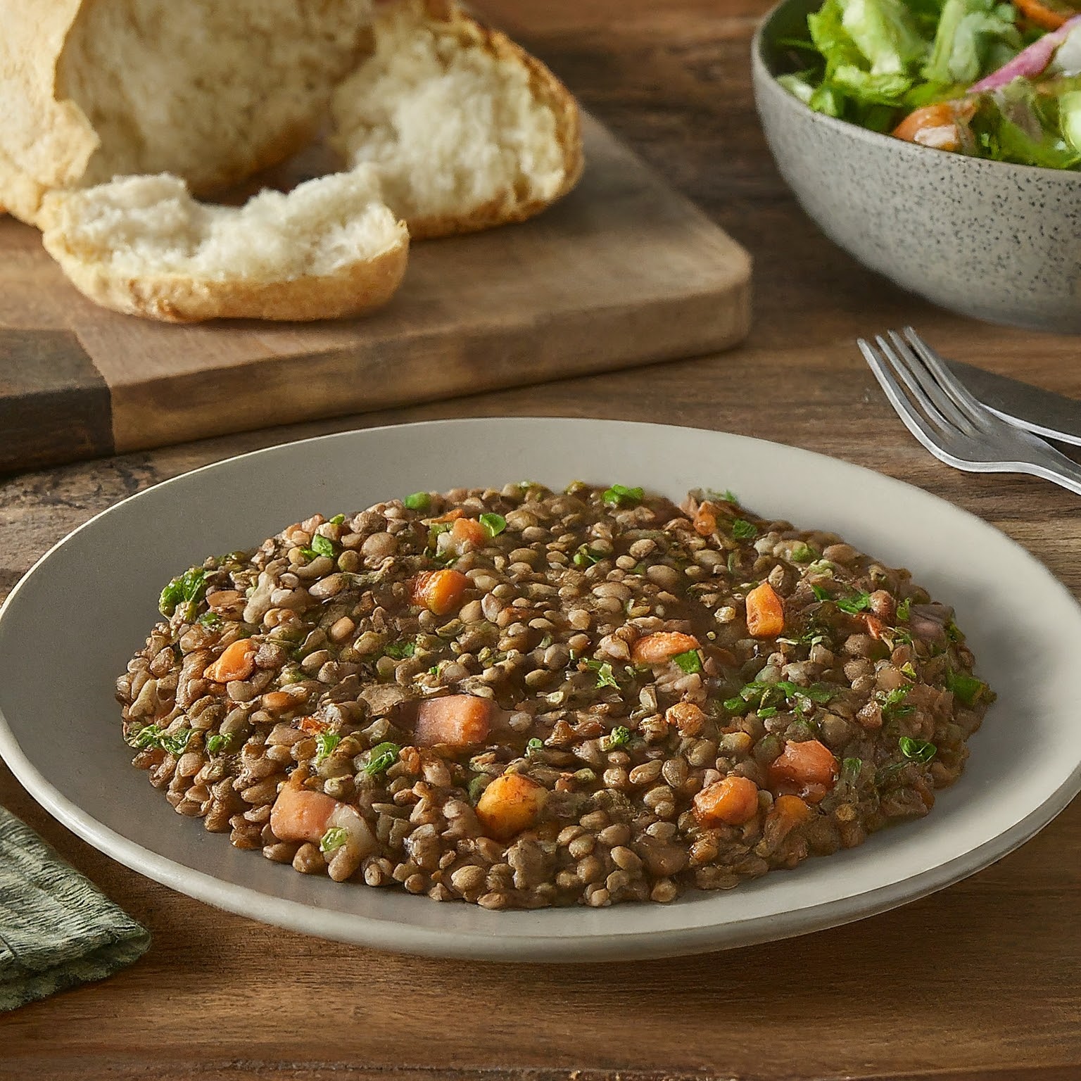 A plate of lentils topped with chopped tomatoes and coriander