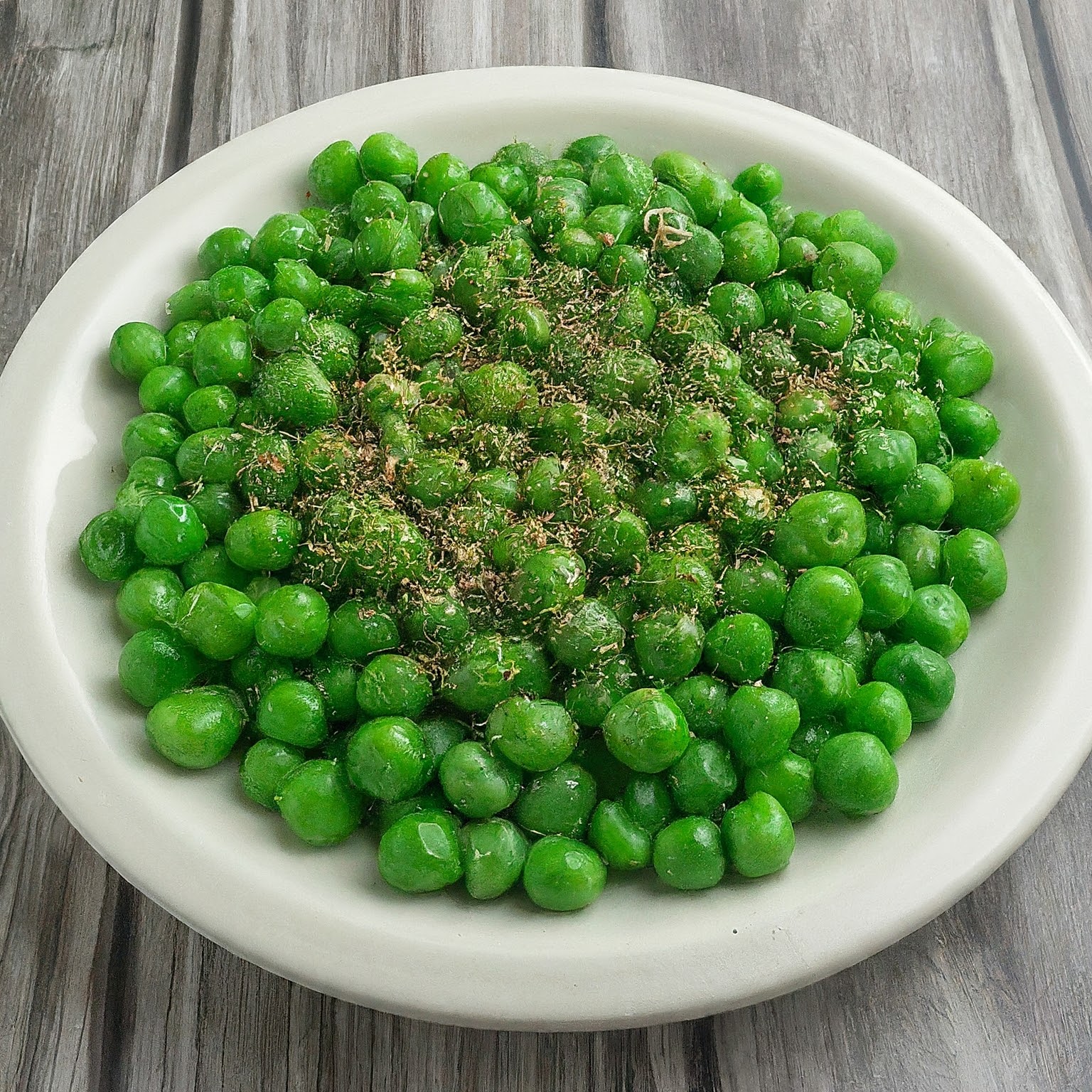 A plate of steamed chickpeas topped with pepper