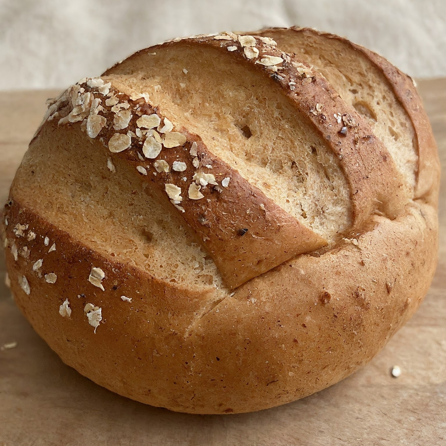 A loaf of whole wheat bread topped with oats