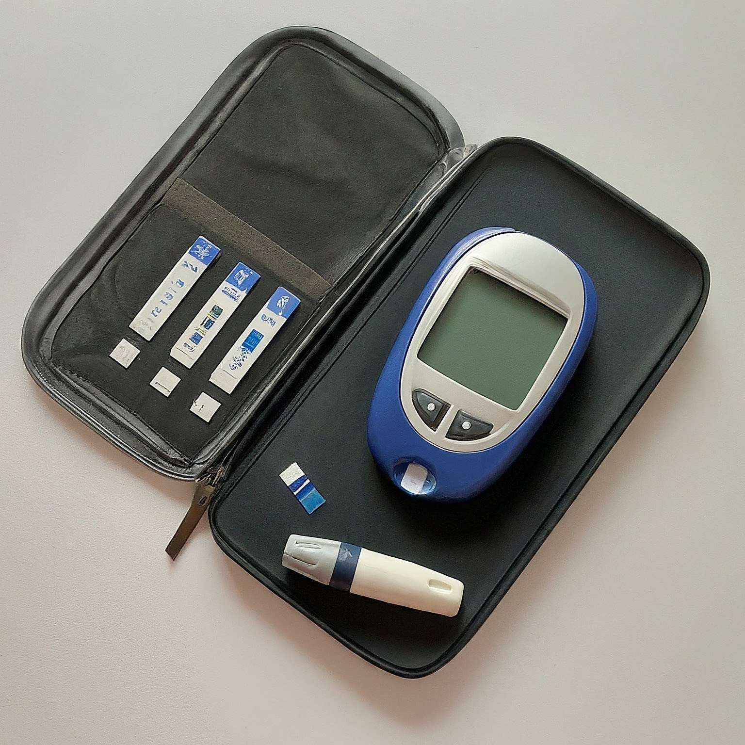 A blood glucose meter with a carrying case and test strips, ready for use.