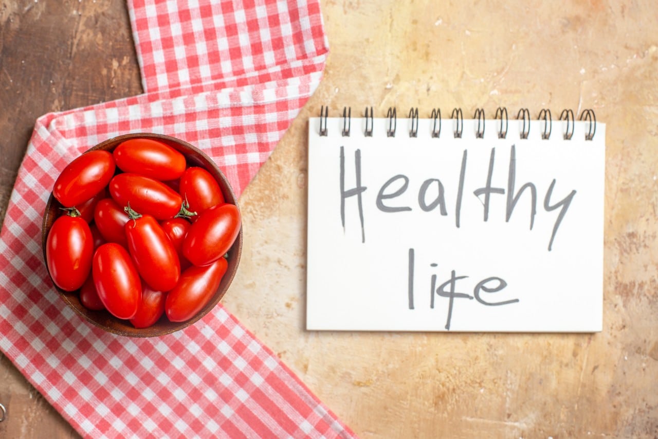 Bowl of tomatoes with a backdrop of healthy life