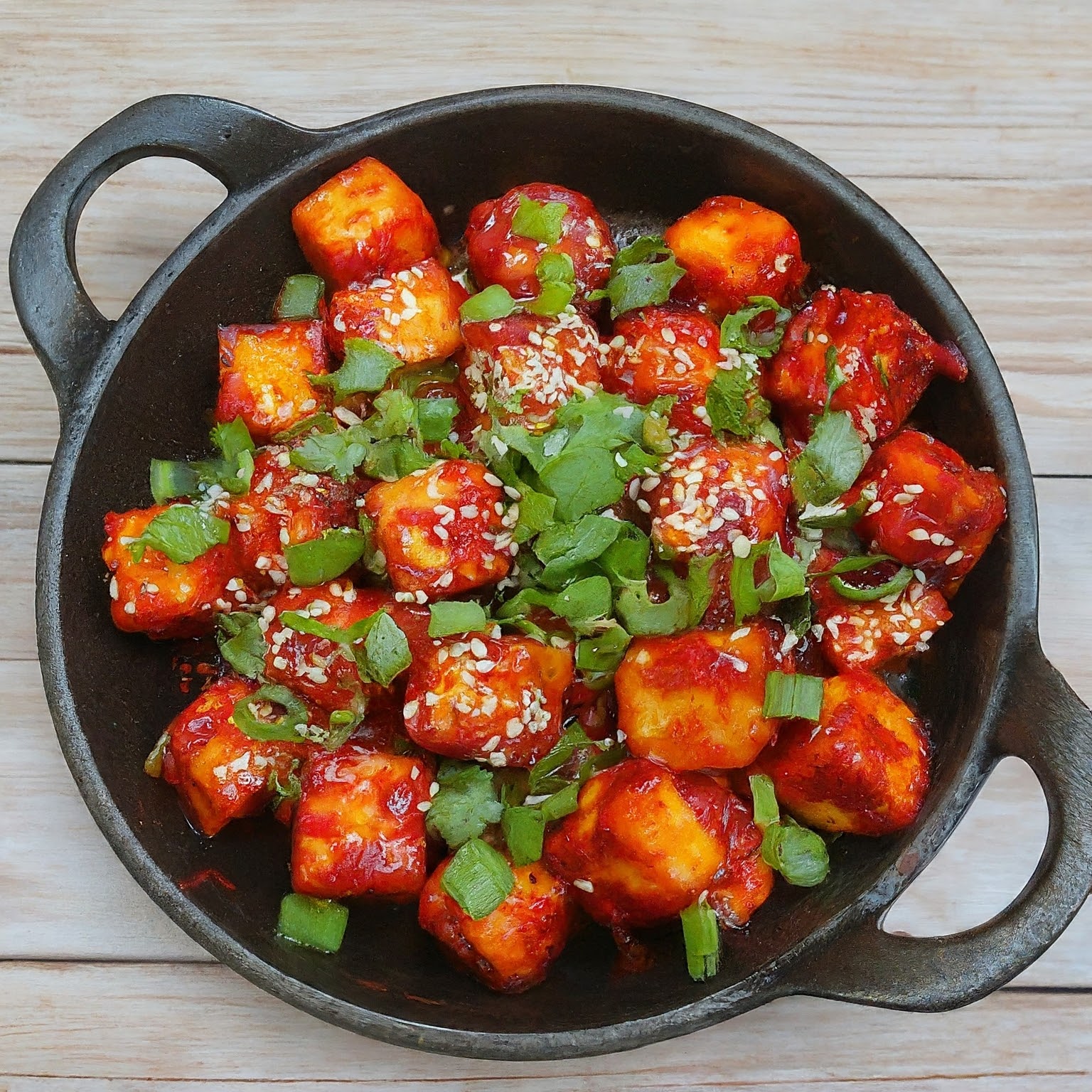 Crispy cubes of paneer coated in a spicy red sauce.