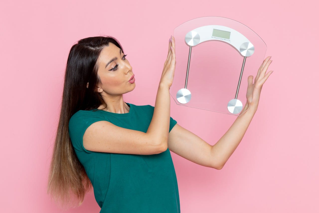 Woman admiring a transparent weight scale.