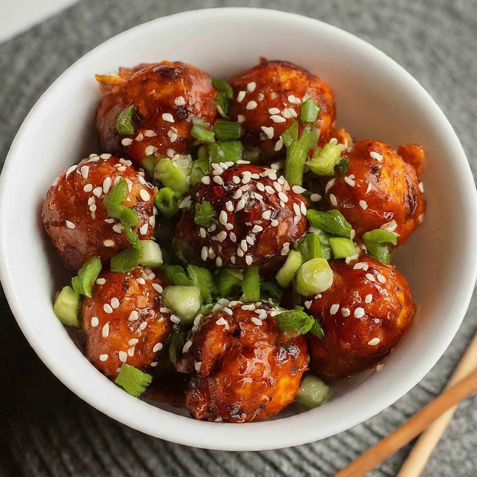 A plate of tangy manchurian, a popular Indian-Chinese dish coated in a sweet and tangy sauce.