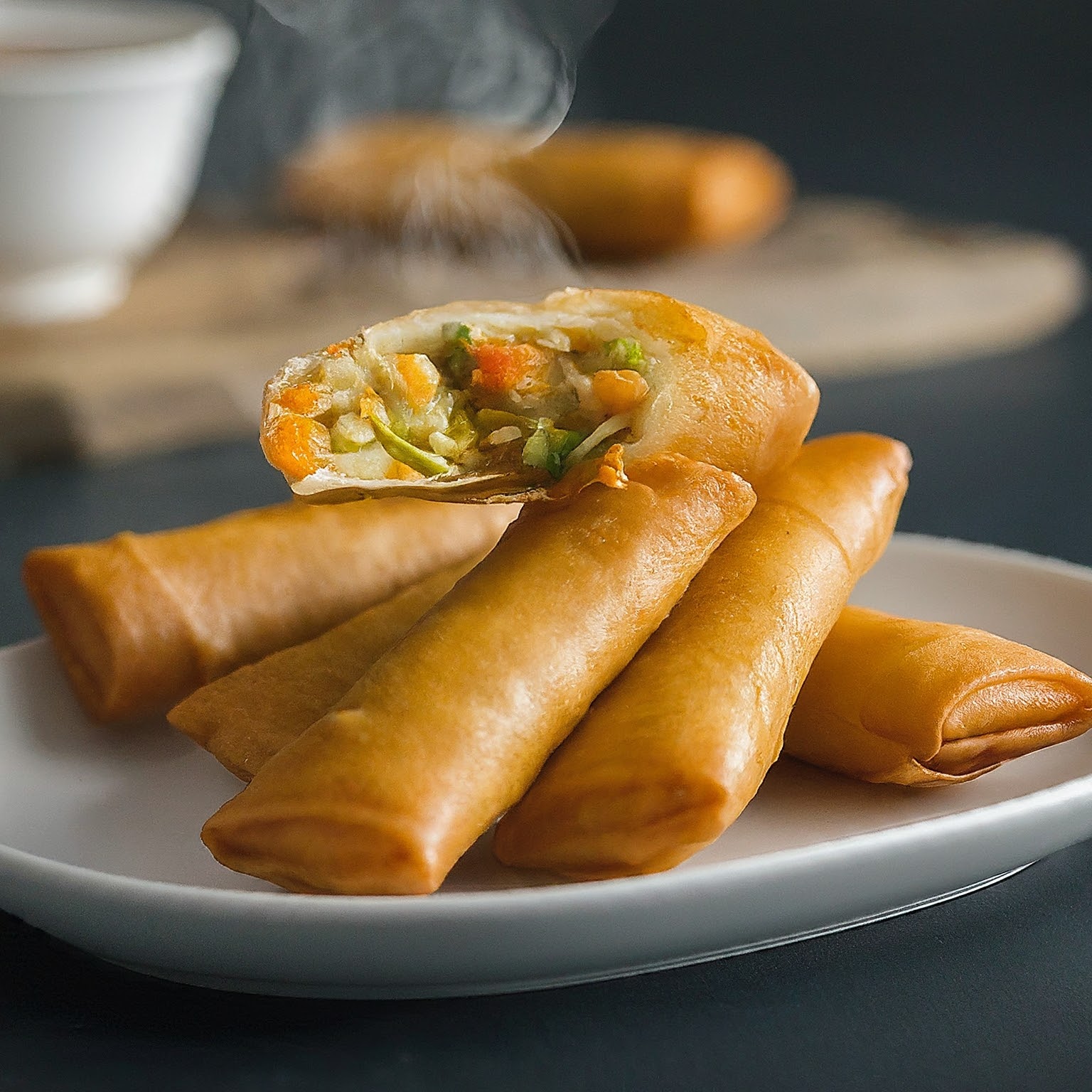 A crispy golden-brown spring roll filled with fresh vegetables.