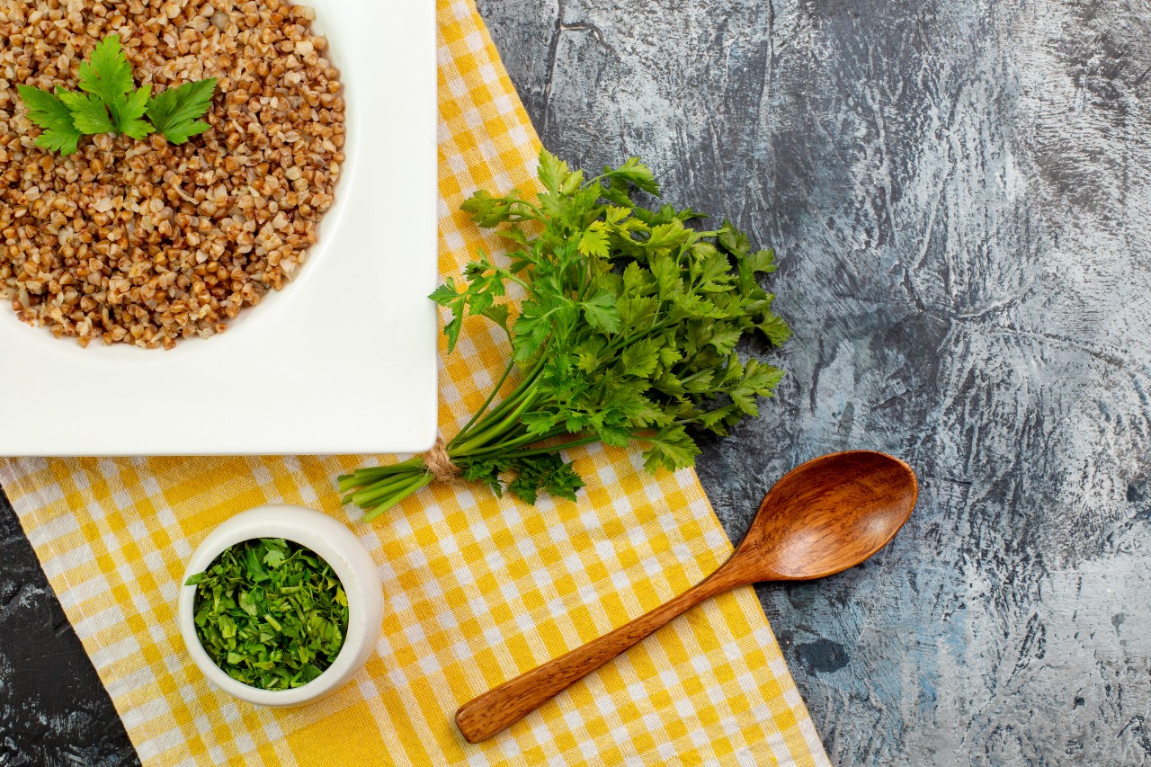 top view tasty cooked buckwheat inside plate with greens light grey table