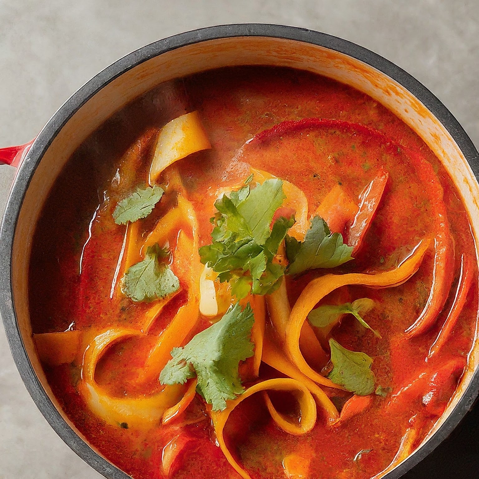 A steaming bowl of restaurant-style vegetarian hot and sour soup, filled with colourful vegetables