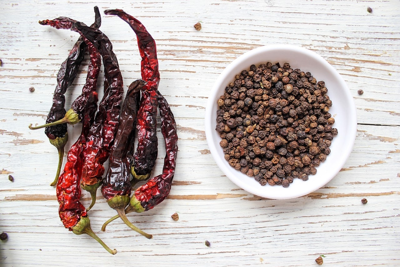 Byadgi chillies with wrinkled skin, wooden background.