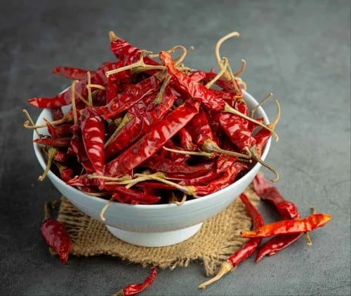 Dried red chillies in a white bowl.