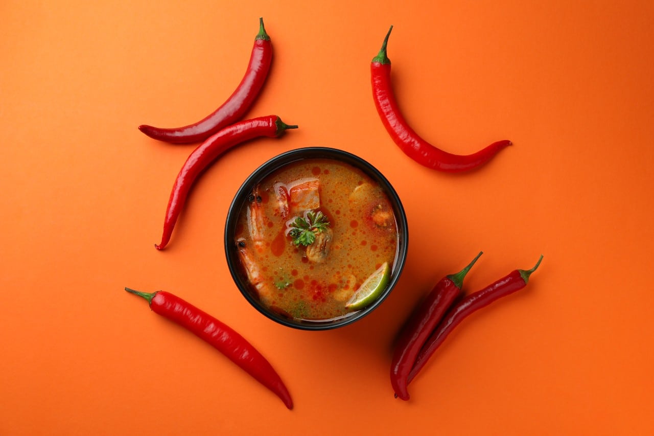 Red chillies encircling soup bowl.