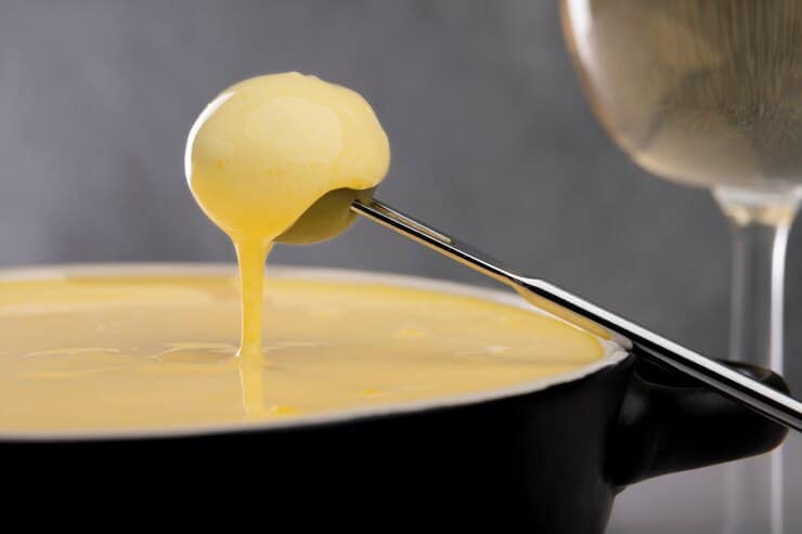 A golden pool of ghee poured with a spoon into a bowl