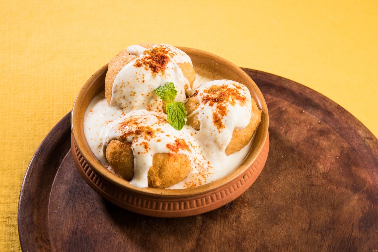 A savoury Indian dish consisting of fried lentil cakes, yoghurt, chutney, and spices