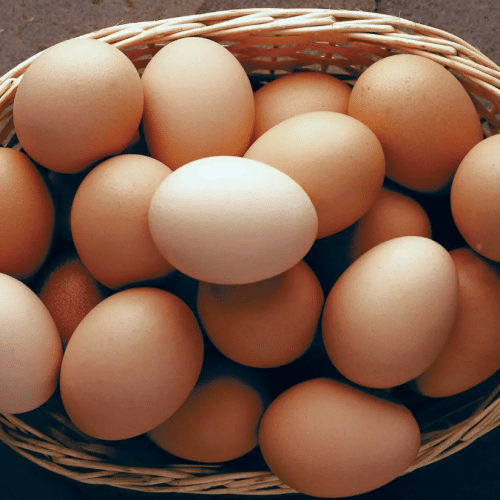 A basket of eggs of mixed colours from white to brown lying on the table