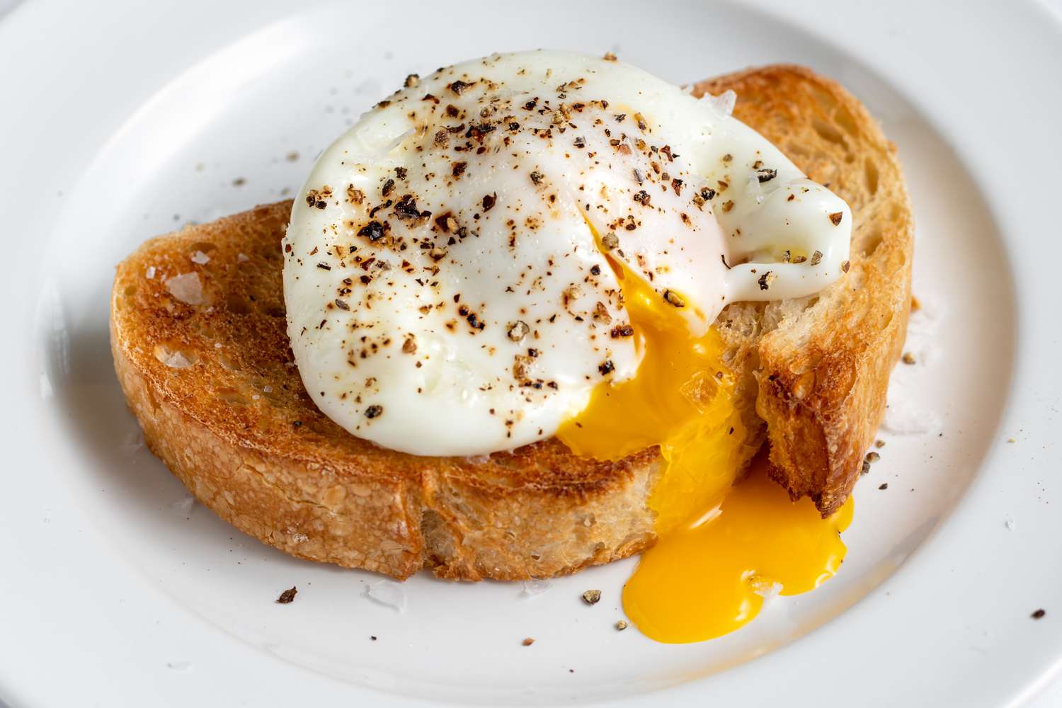 Microwave-poached eggs placed on a toasted bread slice, seasoned with salt, and garnished with parsley.