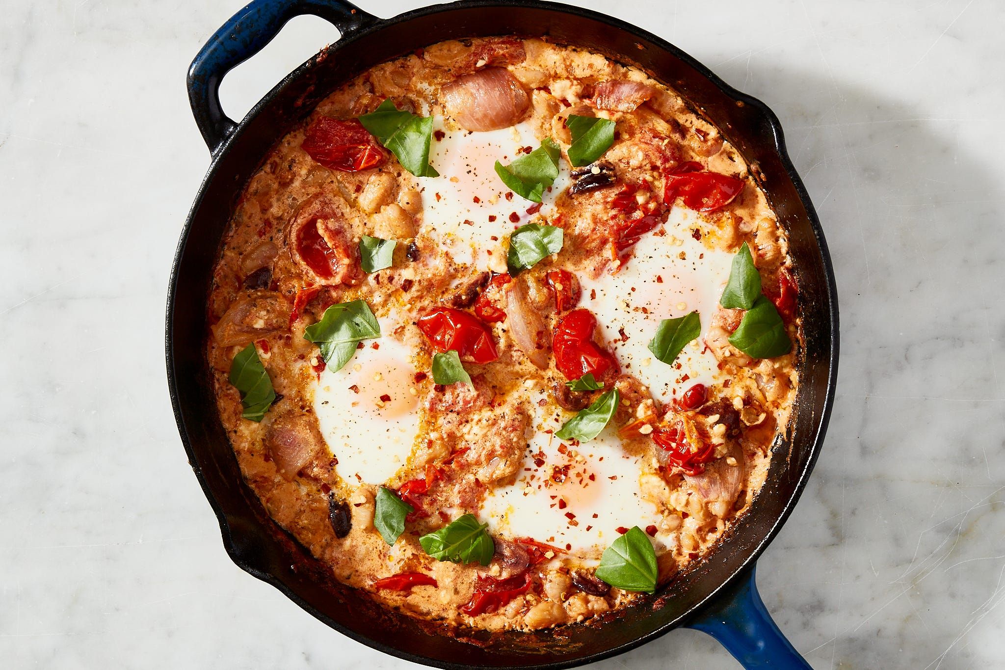 Delicious Tomato and Feta Baked Eggs garnished with fresh parsley, served in a skillet against a rustic backdrop.