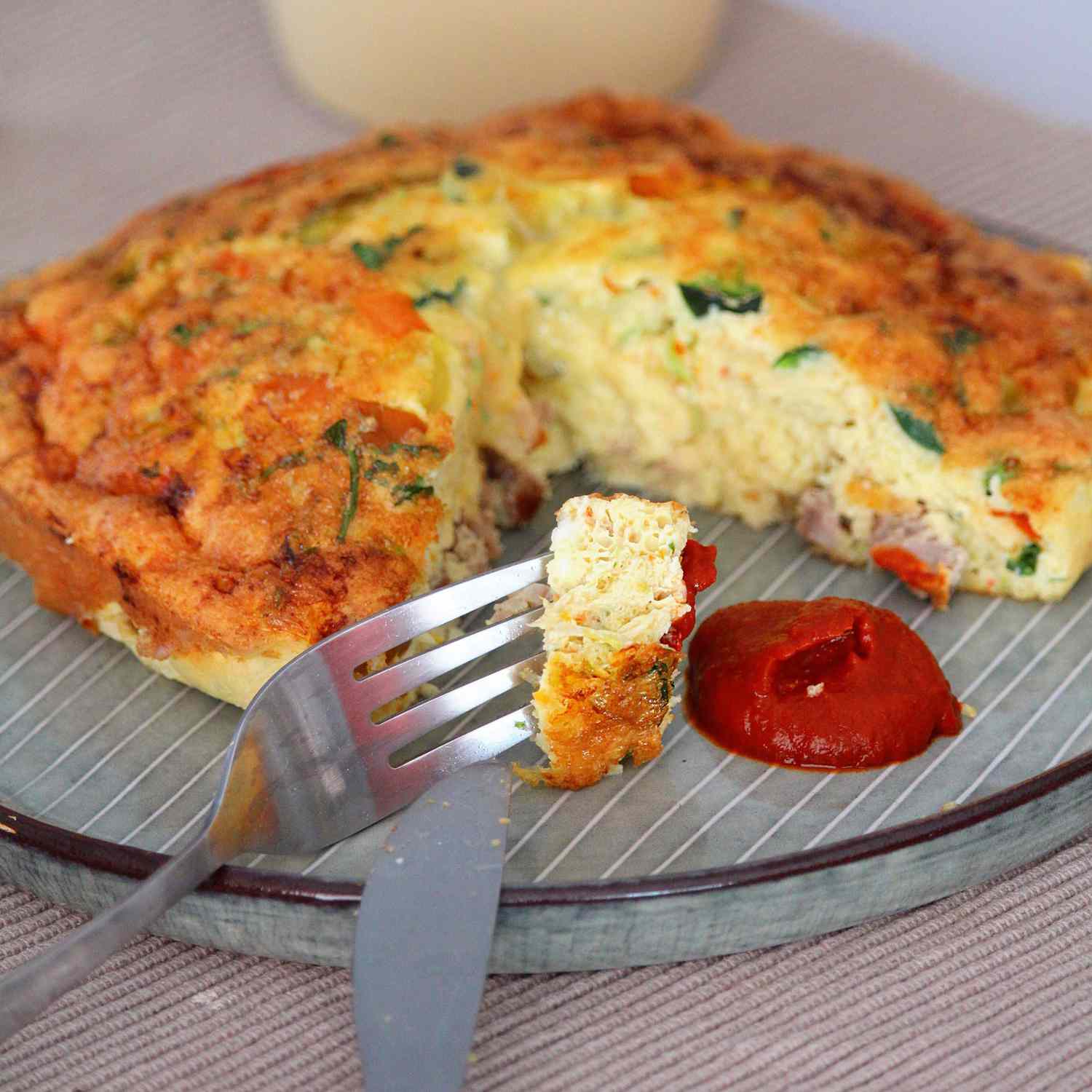 Golden-brown Air Fryer Frittata served on a plate garnished with fresh herbs, portraying a delightful meal.