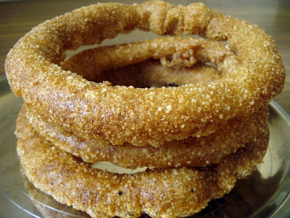 A plate of Sel Roti a traditional Newari sweet bread with a golden brown crust