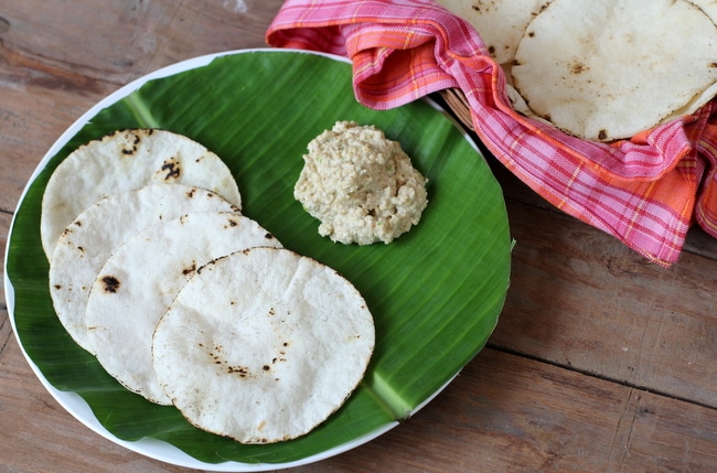 Four akki otis placed on green leaf set on a white plate