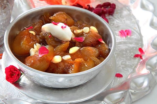 Qubani ka meetha is served with rose petals garnishing