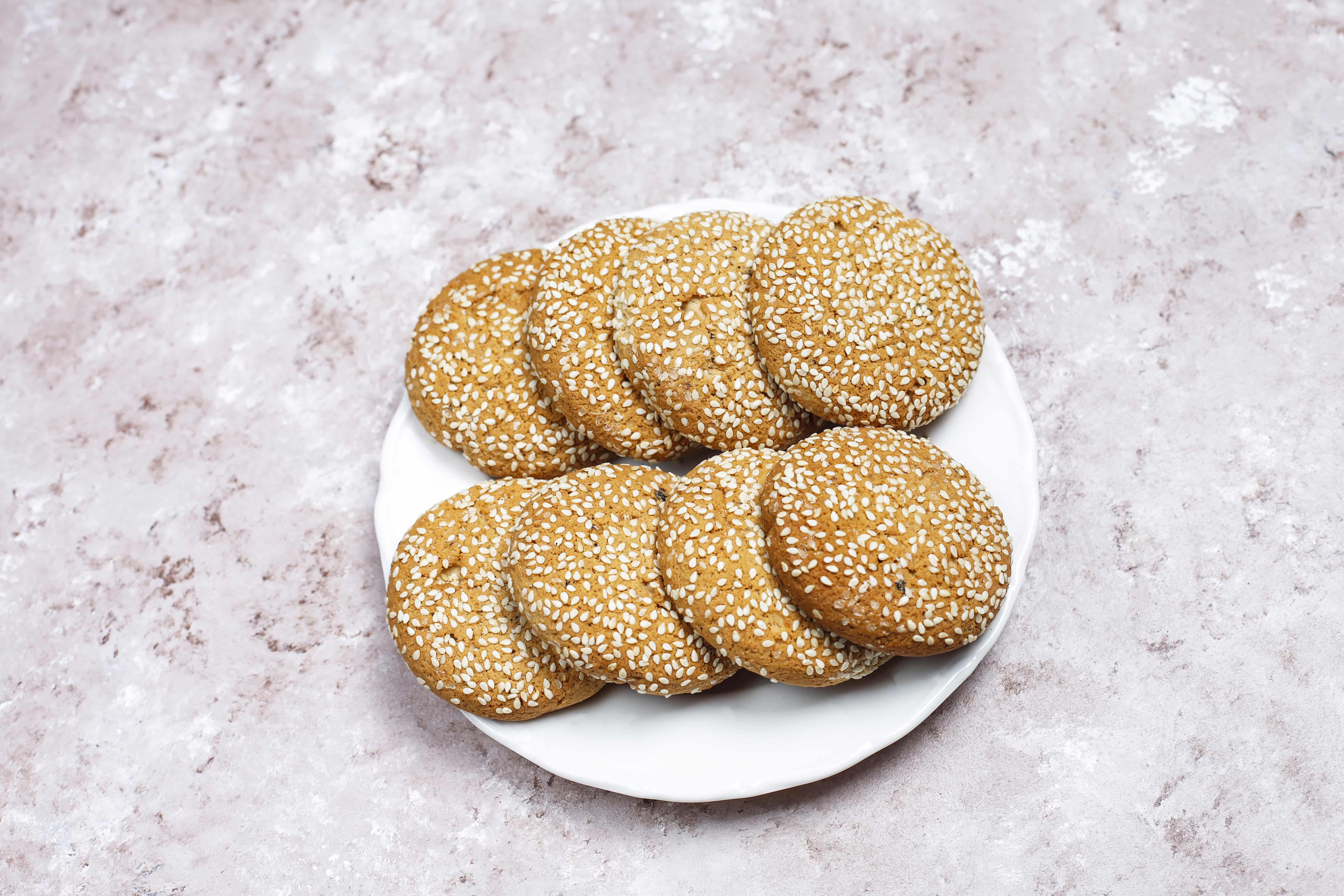 American style sesame seed cookies on light concrete background 